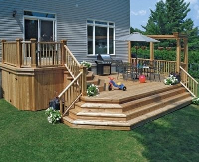 Large backyard wooden deck with railings