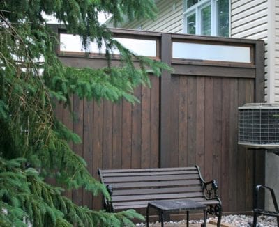 Dark wood privacy fence with bench in front