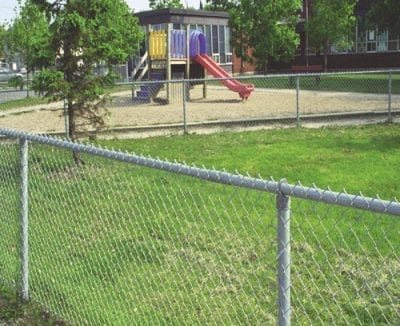 Chain link fence separating the park from the school