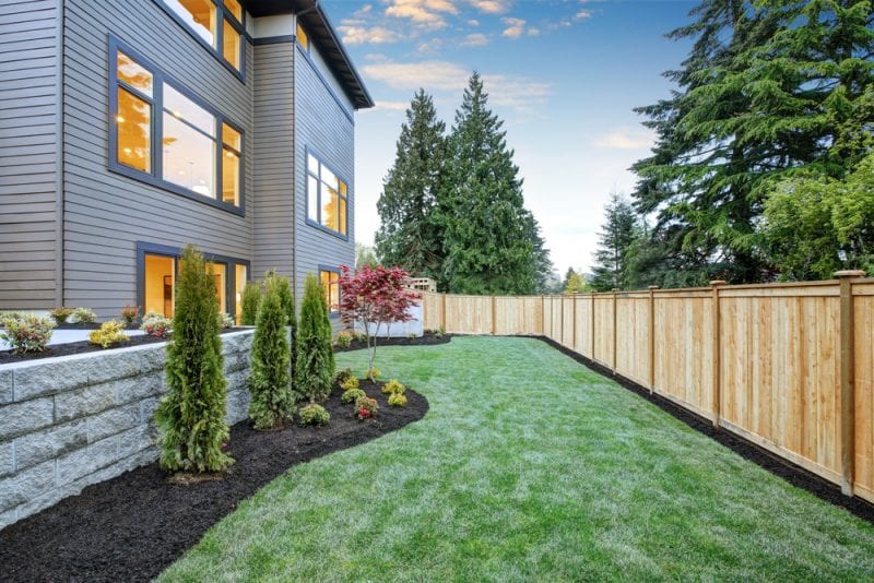 Newly landscaped home with fence surrounding it