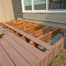 Contractor replacing deck boards during a deck re and re project using composite decking on an existing wooden frame.