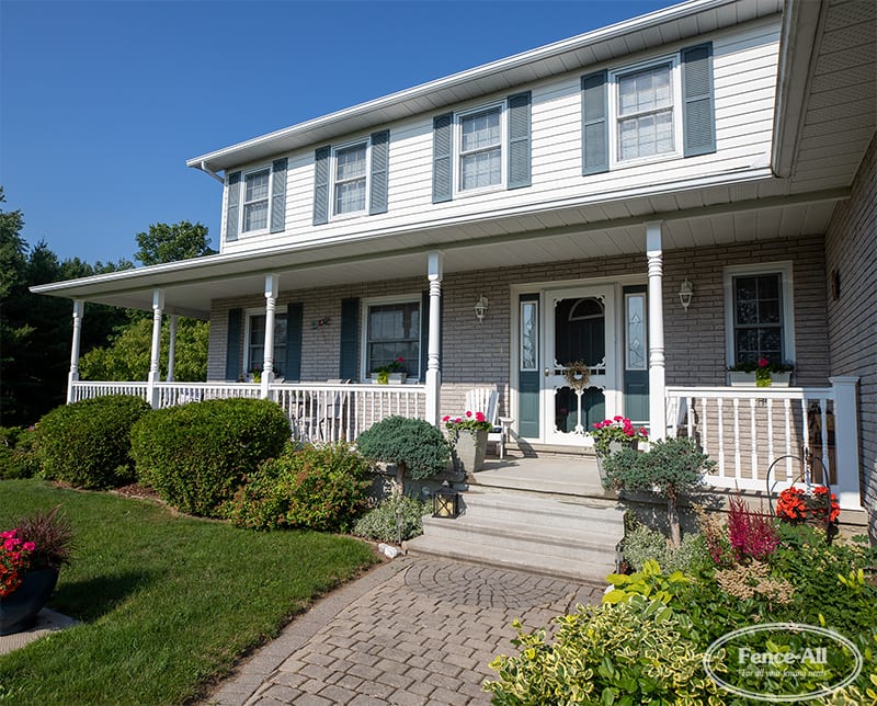 Custom vinyl railings and front porch design installed by Fence-All, enhancing curb appeal and creating a cohesive exterior for an Ottawa home.
